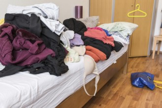 Messy teenager room. Untidy cluttered bed, dirty clothes. Compulsive Hoarding Syndrom