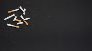 Top view broken cigarette with tobacco black backdrop