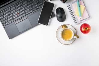Working place and office desk with coffee, laptop, apple, headset and smarthpone. Flatlay in black