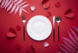 Romantic dinner at restaurant on Valentines day, paper art. White empty plate, spoon, fork, knife