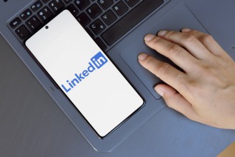 In this photo illustration, the LinkedIn logo is displayed on a smartphone screen