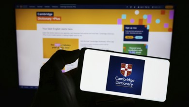 Stuttgart, Germany, 07-11-2023: Person holding cellphone with logo of Cambridge Dictionary on