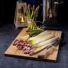 White and green asparagus on kitchen board