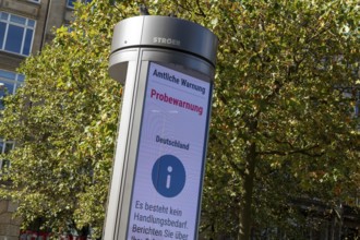 Symbolic image disaster control, advertising pillar with the display Official warning, test