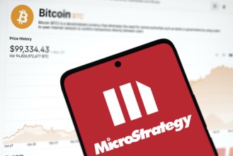 microstrategy logo is displayed on smartphone and Bitcoin price on the background.