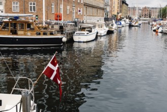 Copenhagen, Denmark, August 12, 2016: Port of Copenhagen with boats and ships moored. Danish flag