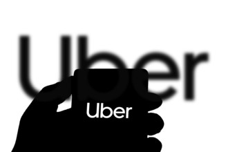 Uber logo on smartphone, Uber is an American company offering transportation services online.