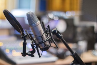 Professional studio microphone, recording studio, equipment in the blurry background