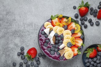 Healthy summer acai smoothie bowl with chia seeds, fresh banana, strawberry, blueberry, cocos, kiwi