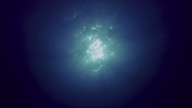 View of sun light from blue abyss, slow motion. Light filters down through blue water. Underwater