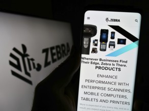 Stuttgart, Germany, 08-13-2023: Person holding cellphone with webpage of US company Zebra