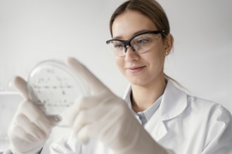 Medium shot scientist holding petri dish