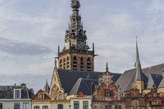 View of church tower and roofs of historic buildings under a cloudy sky, nijmegen, waal,
