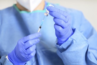 Doctor holding a syringe with a single bottle vial of Covid-19 vaccine. Concept fight against virus