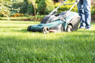 Man pushing lawn mower. Lawn care background, place for text