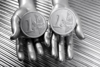 Two silver euro coins in futuristic robot gray metallic hands bank metaphor