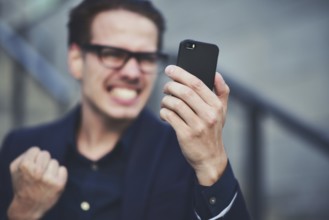 Happy caucasian businessman in glasses dressed at classic wear standing at the street