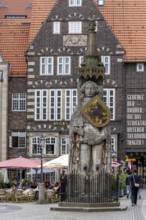 Stone statue with armour and coat of arms Bremen Roland on the market square in the old town of