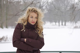 sad woman freezing in snow covered winter landscape