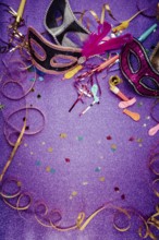 Carnival Mask, Streamers And Confetti For Festive Background in violet tone with copy space