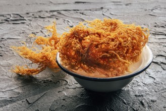 Irish sea moss, Chondrus Crispus, healthy organic raw seaweed, dried, in a bowl on a black slate