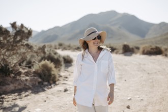 Woman with sunglasses and sun hat on a gravel road, South Africa, Africa