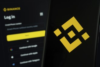 Binance logo is displayed on a smartphone screen, with the binance login page visible on a computer