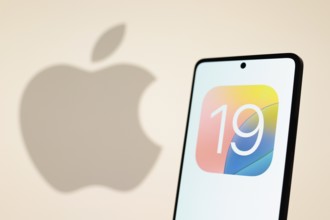 In this photo illustration, the iOS 19 logo seen displayed on a smartphone with an Apple logo in