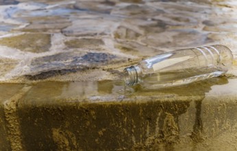 Close-up of a plastic water bottle spilling water on a flight of stairs