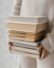 Close up hands holding books stack