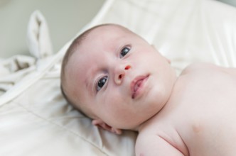 Beautiful happy newborn baby lying