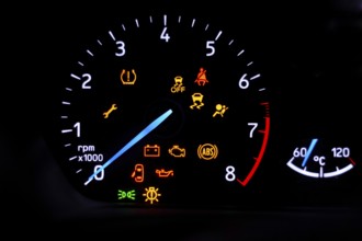 A car's dashboard lights up with multiple alert icons, signaling various vehicle functions and