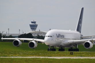 Lufthansa Airbus A380-800 with control tower taxiing from Terminal 2 to Runway North, Munich