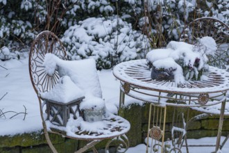 Snow-covered garden table with chairs, decoratively placed in the winter garden, Weseke, borken,