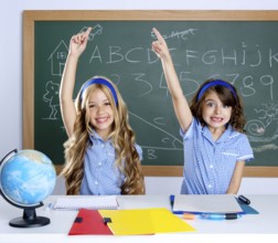 Smart students in classroom raising hand with blackboard