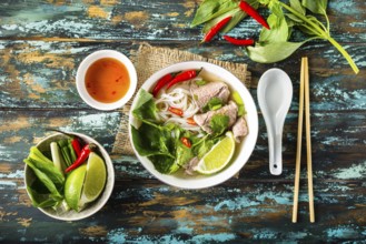 Traditional Vietnamese soup Pho bo with herbs, meat, rice noodles, broth. Pho bo in bowl with