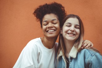 Portrait of two happy joyful teen girls of different races smiling at camera, enjoying friendship,