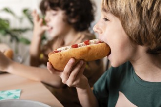 Kids eating hot dogs together