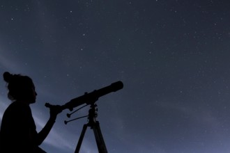 Woman with telescope watching the stars. Stargazing woman and night sky