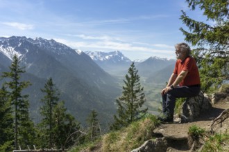 Hiker, senior citizen, 66, resting on the summit of the Osterfeuerkopf with a view of the