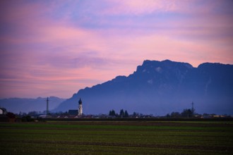 Church in front of mountains and pink sunset sky, fields in the foreground, Ainring, Upper Bavaria