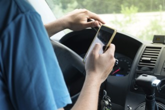 Photo of a man using smartphone while driving the car, transportation and vehicle concept with icon