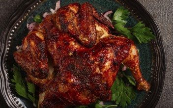 Whole fried chicken, with spices, grilled chicken, on a plate, top view, homemade, no people