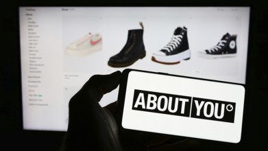 Stuttgart, Germany, 03-14-2023: Person holding cellphone with logo of German e-commerce company