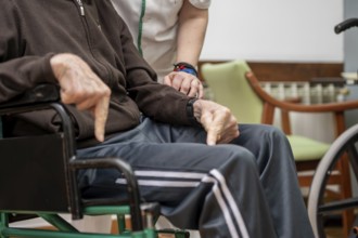 Caregiver assisting elderly man in dining room at nursing home. graphy