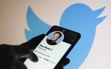 In this photo illustration, the Elon Musk Twitter account displayed on a smartphone screen and