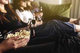 Friend group of people in 3D glasses are watching a movie, smiling, laughing. Eating and drinking