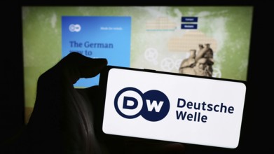 Stuttgart, Germany, 04-10-2024: Person holding mobile phone with logo of German state-owned