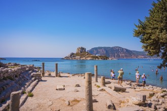 Ancient ruins on the shore with a view of the sea and a rocky island in the background, Agios