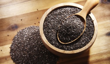 Bowl of chia seeds on wooden table